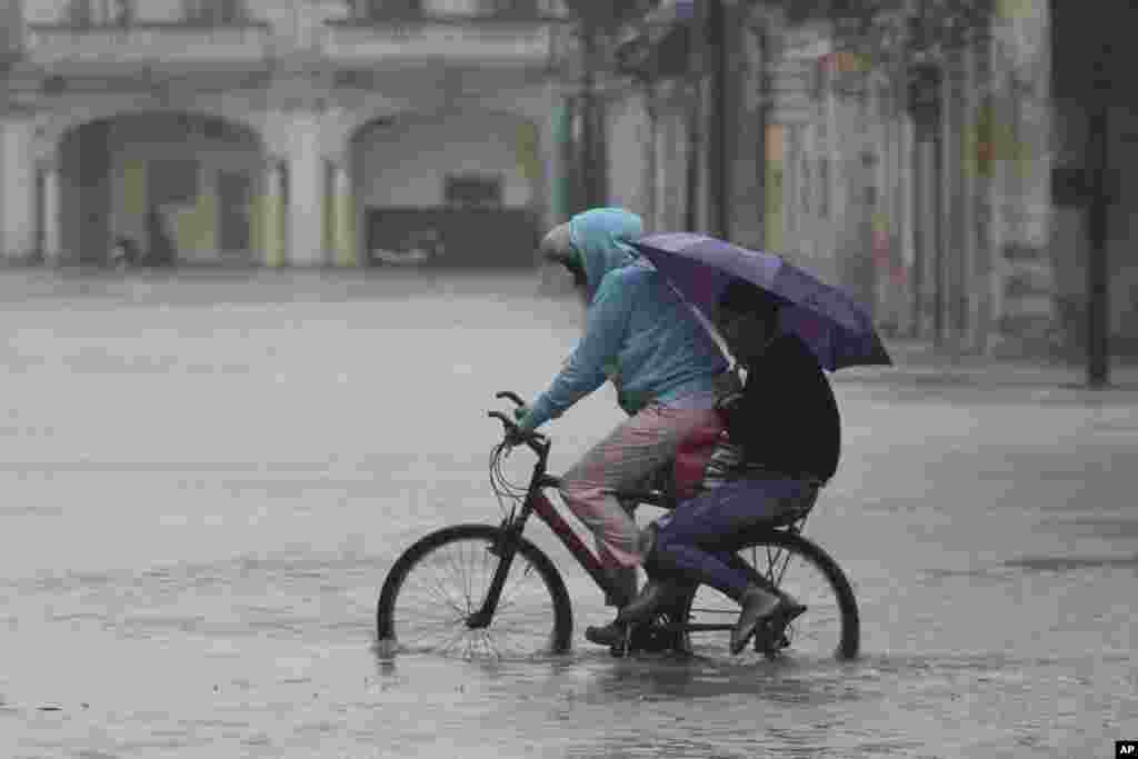 En bicicleta por una calle inundada tras el paso de Idalia, en La Habana, Cuba.