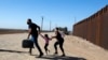 Una familia de migrantes cubanos se apresura a cruzar la frontera en Yuma, Arizona, en mayo de 2021. (Ringo Chiu/ AFP)