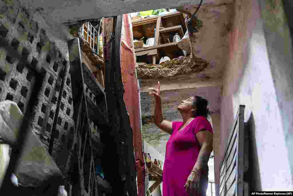 Una mujer señala los daños en su techo, sobre el segundo piso, causados por el huracán Ian en Pinar del Río, Cuba, el martes 27 de septiembre de 2022. (AP Foto/Ramón Espinosa)