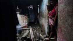 Luzanne de la Castro y su hija se encuentran en la puerta de su casa dañada por el huracán Ian en Pinar del Río, Cuba, 27 de septiembre de 2022. REUTERS/Alexandre Meneghini