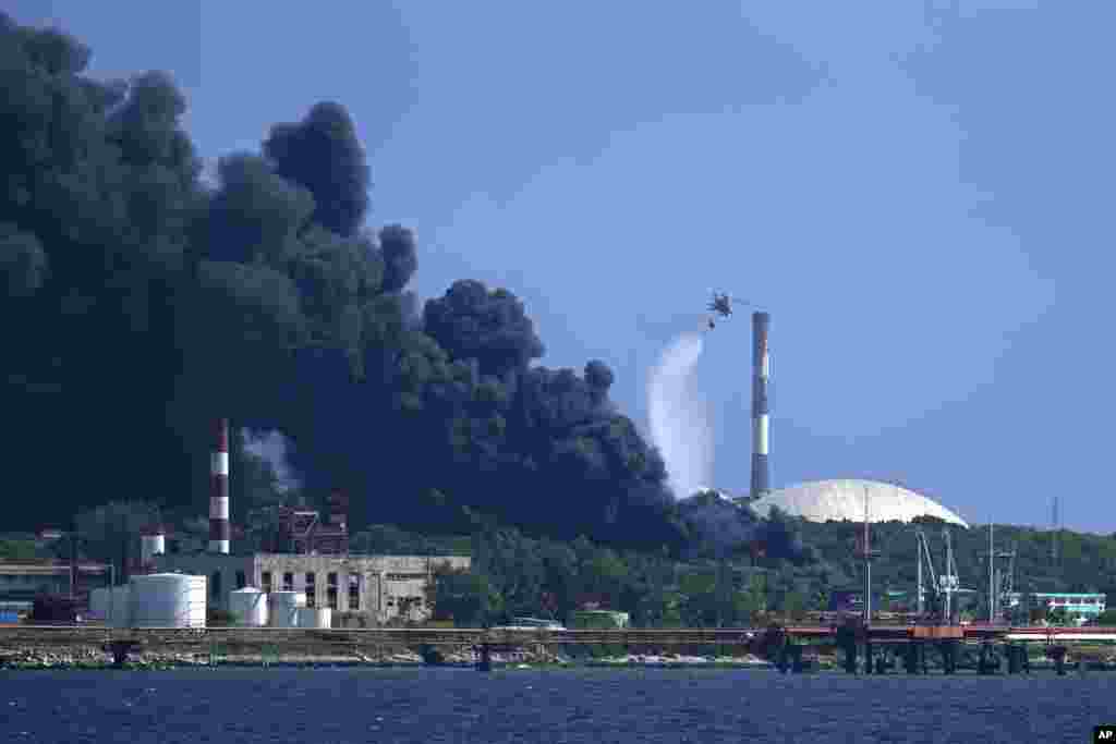 Un helicóptero arroja agua sobre el incendio. 