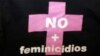 Una mujer sostiene una camisa con la frase "No mas Feminicidios "