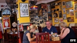 Tres turistas almuerzan en un restaurante privado en La Habana.