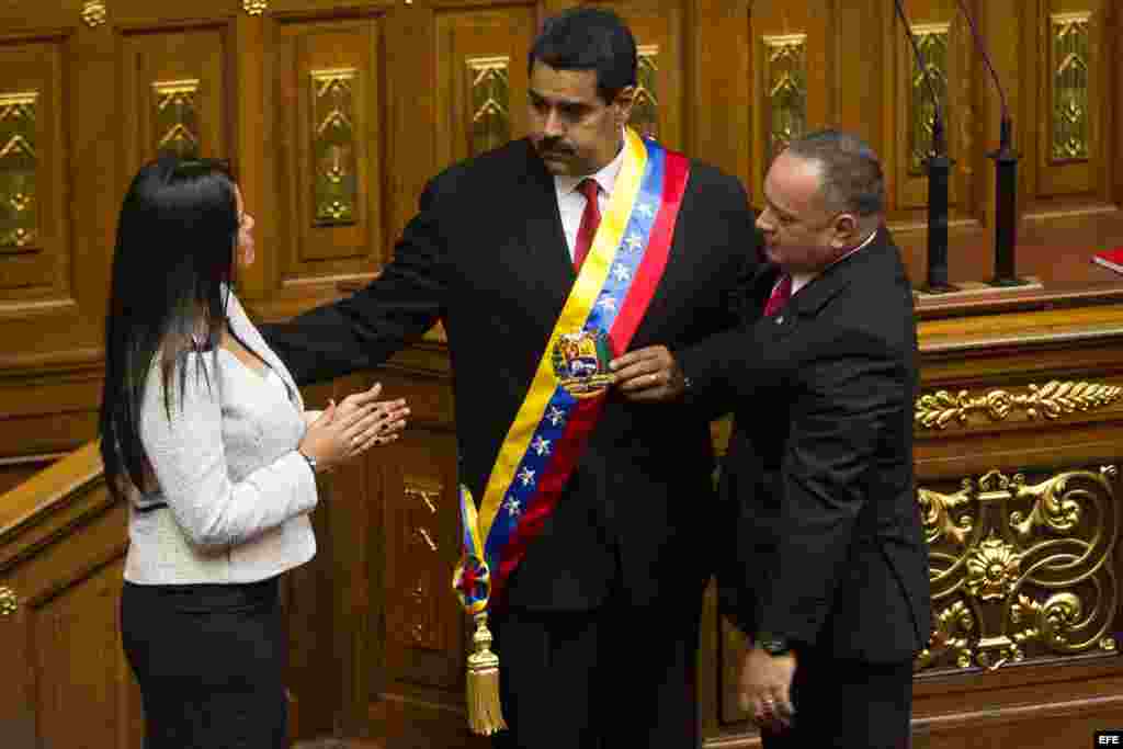 Nicolás Maduro (c), recibe la banda presidencial de manos del presidente de la Asamblea Nacional, Diosdado Cabello (d), y de la hija del fallecido presidente venezolano Hugo Chávez, María Gabriela Chávez (i).