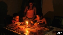 Niños comen a la luz de una vela durante un apagón en Cuba en el año 2009.
