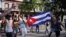 Manifestantes sostienen la bandera cubana durante las protestas en contra del gobierno, en La Habana, el 11 de julio de 2021. (REUTERS / Alexandre Meneghini)