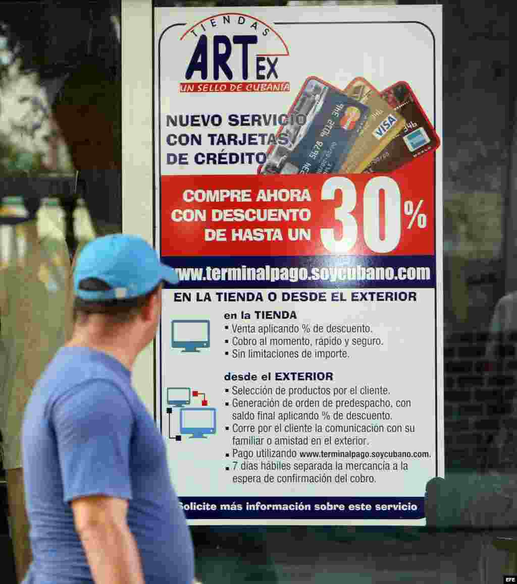 Un hombre pasa frente a un cartel con anuncio de compras on-line de una tienda cubana en La Habana, hoy sábado 15 de noviembre de 2014.