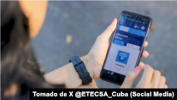 Una joven chequea la tienda online de ETECSA.