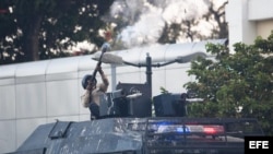 Miembros de la Policía Nacional Bolivariana disparan contra opositores.