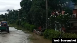 Las aguas continúan altas en la comunidad de Guamo, y otras zona del municipio Río Cauto. Los residentes esperan en lo alto de una vivienda ser rescatados. 