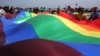 Activistas LGBTI ondean la bandera que los representa en El Malecón.