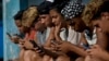 Jóvenes cubanos se conectan a internet desde su teléfono móvil en La Habana (Foto: Archivo).