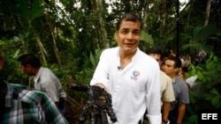 Foto de archivo del expresidente Rafael Correa con la mano manchada de crudo de un reservorio antiguo de desechos petroleros en la Amazonía.