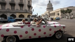 Turistas se pasean en un auto clásico cerca del Capitolio, en La Habana.