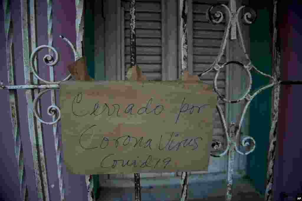Un cartel de "Cerrado por coronavirus COVID-19" cuelga de la puerta de un negocio en La Habana. (AP/Ismael Francisco)