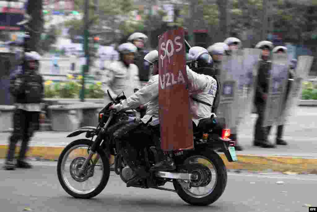 Miembros de la Policía Nacional Bolivariana (PNB) son vistos el jueves 13 de marzo de 2014, durante nuevos enfrentamientos con manifestantes opositores en la Plaza Altamira de Caracas (Venezuela).